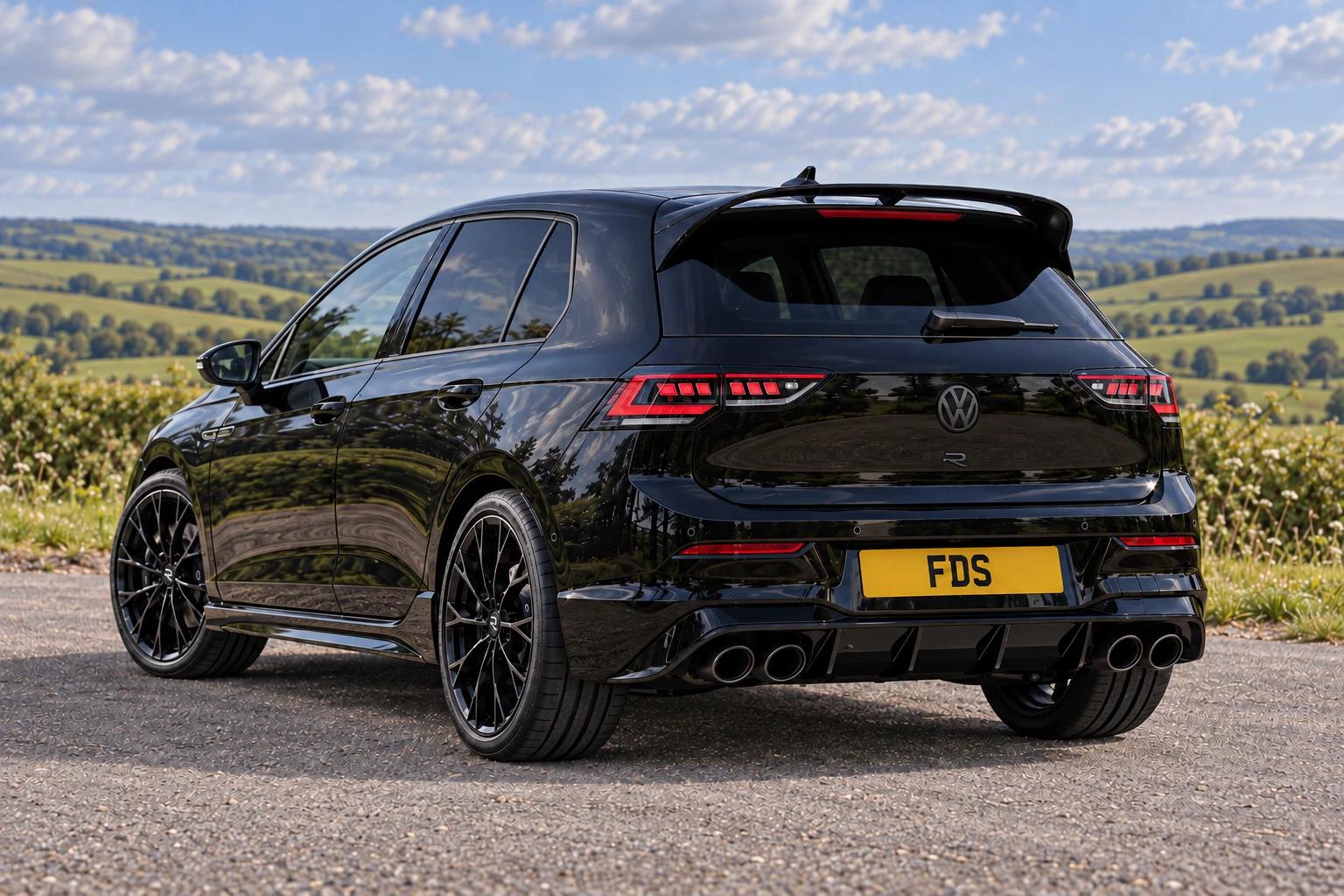 Black Volkswagen Golf R Black Edition, rear three-quarter view at a countryside viewpoint.