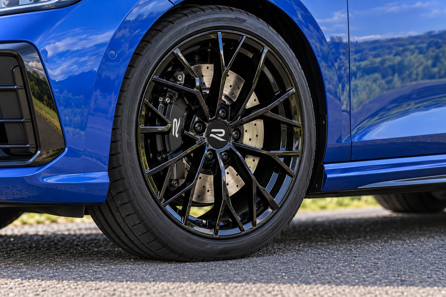 Close-up illustration of an optional black Warmenau alloy wheel on a blue Golf R.